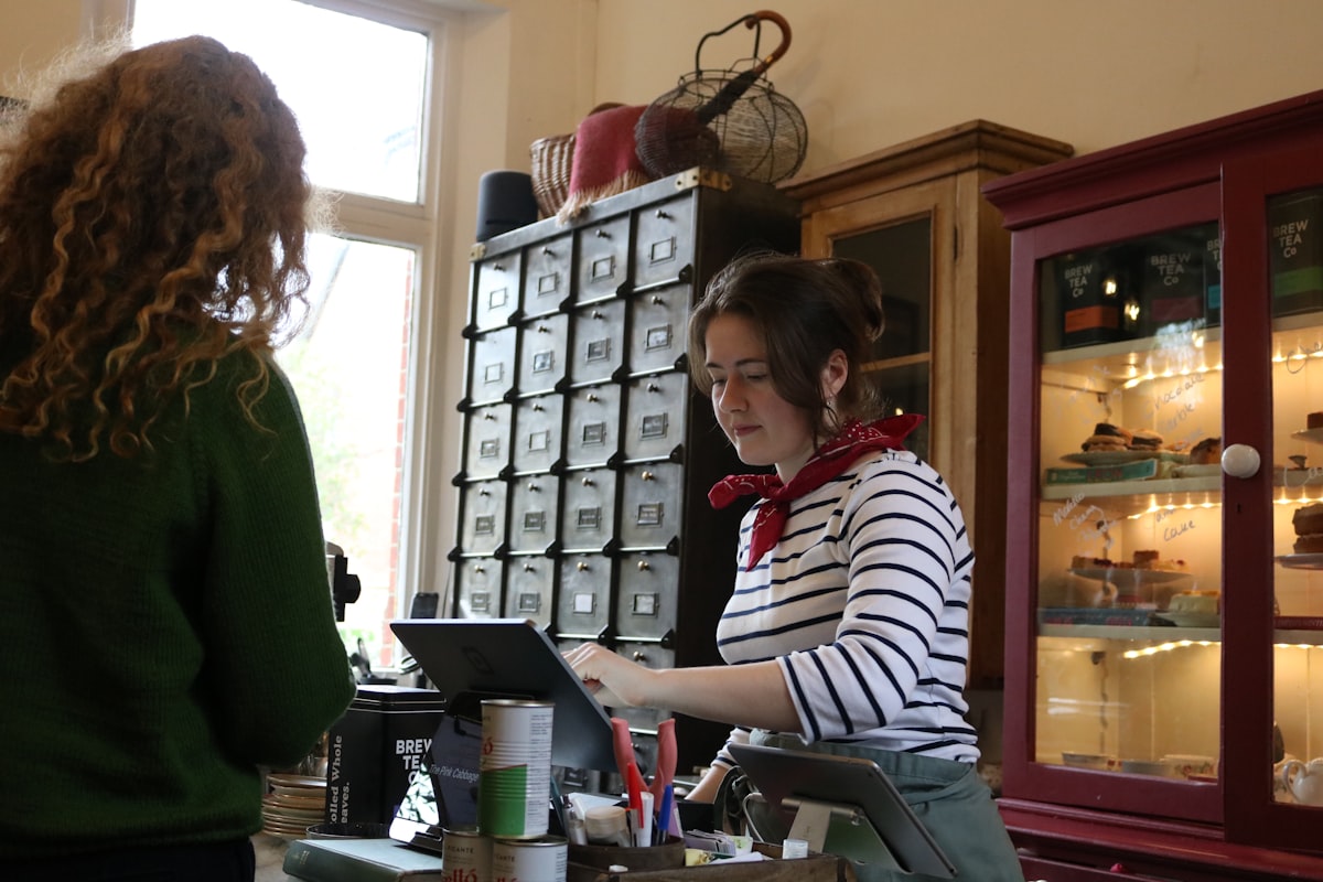 Cashier serving a customer at a local cafe counter